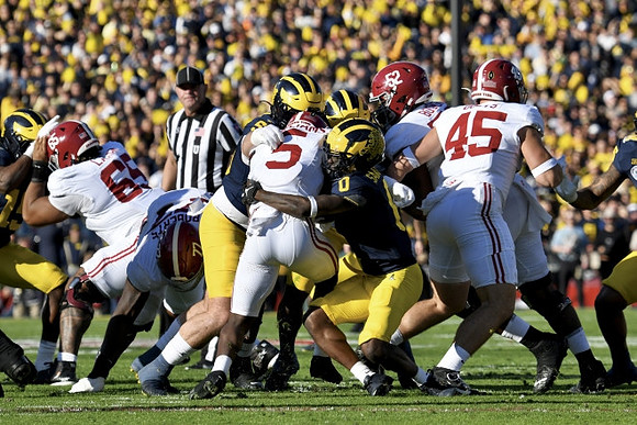 Mason Graham (55) and Mike Sainristil (0)