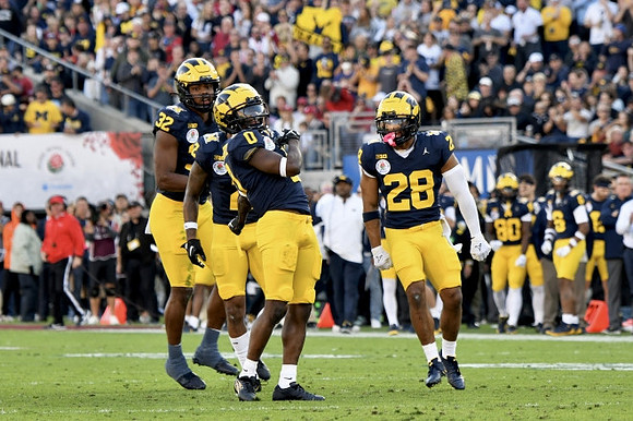 Jaylen Harrell (32), Mike Sainristil (0), and Quinten Johnson (28)