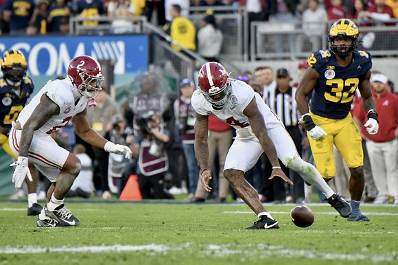 Mike Sainristil (0) and Jaylen Harrell (32)