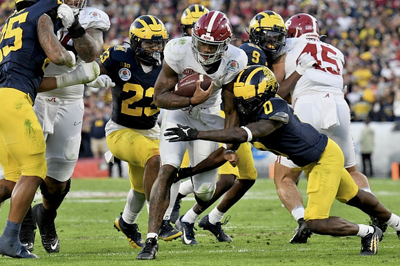 Junior Colson (25), Michael Barrett (23), Mike Sainristil (0), and Rod Moore (9)