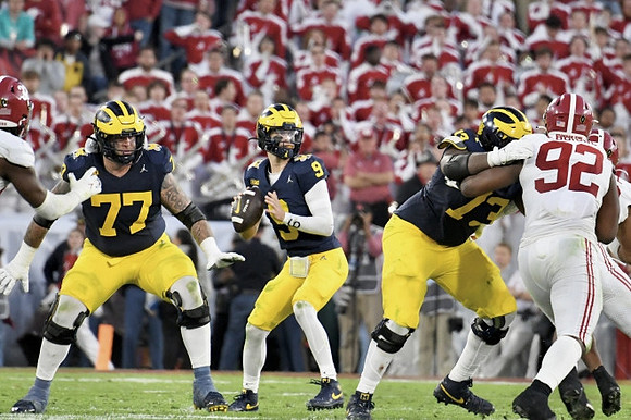 Trevor Keegan (77), J.J. McCarthy (9), and LaDarius Henderson (73)