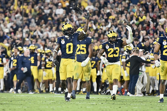 Mike Sainristil (0), Junior Colson (25), Michael Barrett (23), and Quinten Johnson (28)