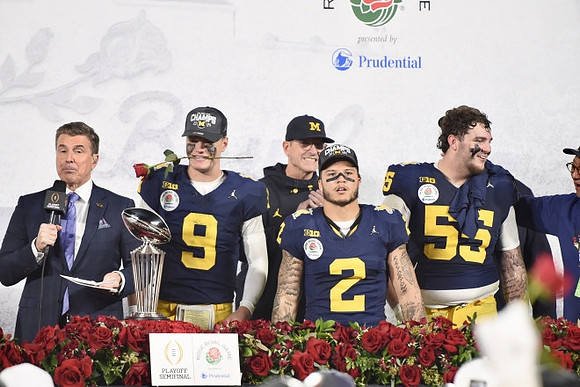 J.J. McCarthy (9), Jim Harbaugh, Blake Corum (2), Mason Graham (55), and Rose Bowl Trophy