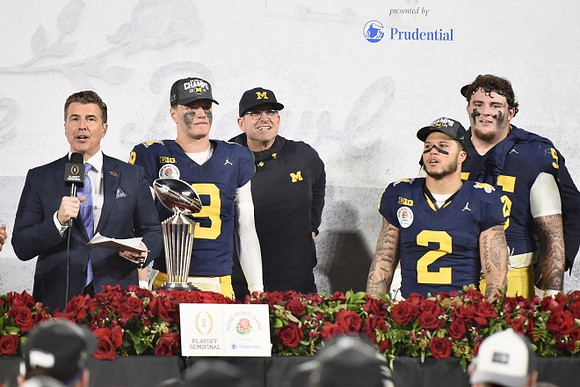 J.J. McCarthy (9), Jim Harbaugh, Blake Corum (2), Mason Graham (55), and Rose Bowl Trophy