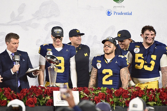 J.J. McCarthy (9), Jim Harbaugh, Blake Corum (2), Mason Graham (55), Warde Manuel, and Rose Bowl Trophy