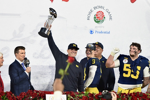 Jim Harbaugh, J.J. McCarthy (9), Warde Manuel, Mason Graham (55), and Rose Bowl Trophy
