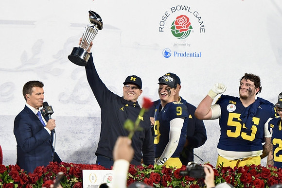 Jim Harbaugh, J.J. McCarthy (9), Warde Manuel, Mason Graham (55), and Rose Bowl Trophy