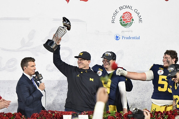 Jim Harbaugh, J.J. McCarthy (9), Mason Graham (55), and Rose Bowl Trophy
