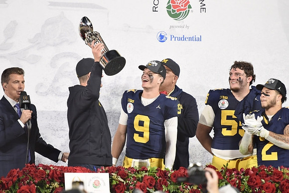 Jim Harbaugh, J.J. McCarthy (9), Warde Manuel, Mason Graham (55), Blake Corum (2), and Rose Bowl Trophy