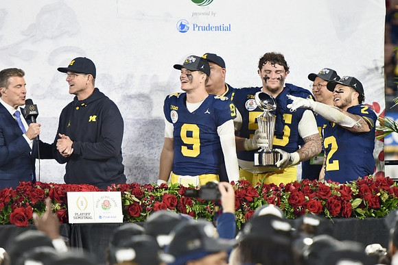 Jim Harbaugh, J.J. McCarthy (9), Warde Manuel, Mason Graham (55), UofM President Santa Ono, Blake Corum (2), and Rose Bowl Trophy