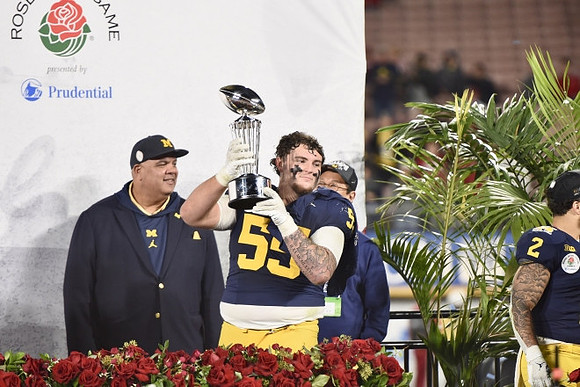 Warde Manuel, Mason Graham (55), UofM President Santa Ono, Blake Corum (2), and Rose Bowl Trophy