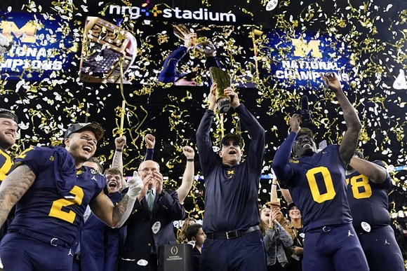 Blake Corum (2), J.J. McCarthy (9), Jim Harbaugh, Mike Sainristil (0), Kenneth Grant (78), and National Championship Trophy