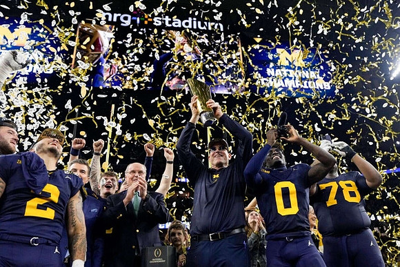 Blake Corum (2), Jim Harbaugh, Mike Sainristil (0), Kenneth Grant (78), and National Championship Trophy