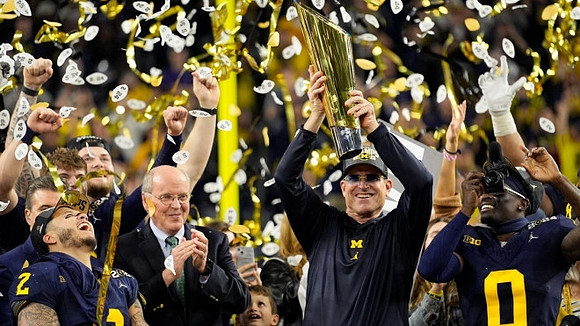 Blake Corum (2), Jim Harbaugh, Mike Sainristil (0), and National Championship Trophy