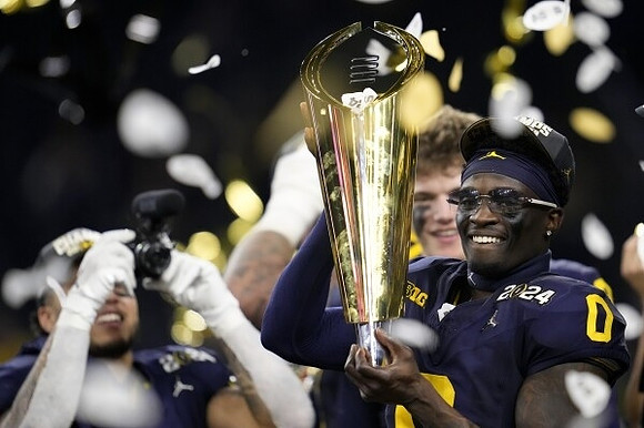 Blake Corum (2), Mike Sainristil (0), J.J. McCarthy (9), and National Championship Trophy