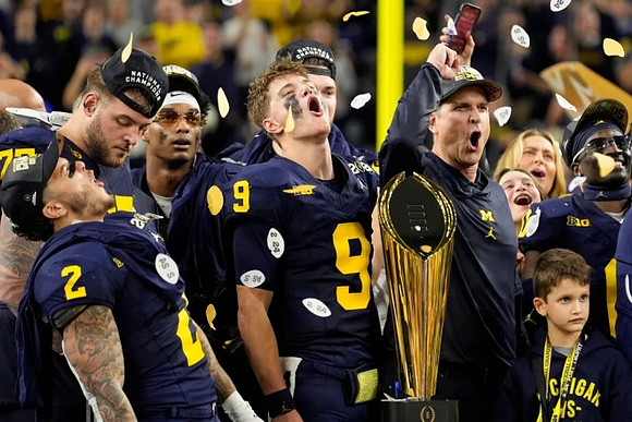 Blake Corum (2), Trevor Keegan (77), Will Johnson (2), J.J. McCarthy (9), Jim Harbaugh, Mike Sainristil (0), and National Championship Trophy