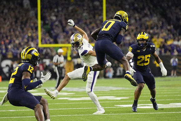 Josh Wallace (12), Mike Sainristil (0), and Junior Colson (25)