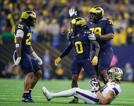 Junior Colson (25), Mike Sainristil (0), and Kenneth Grant (78)