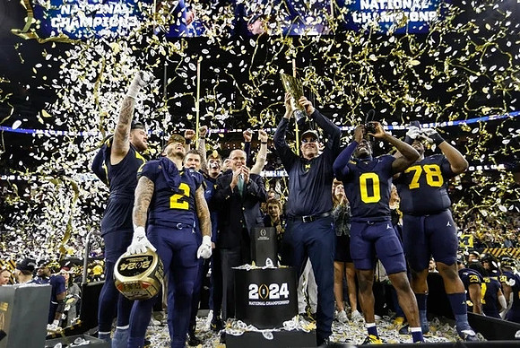 Trevor Keegan (77), Blake Corum (2), Jim Harbaugh, Mike Sainristil (0), Kenneth Grant (78), and National Championship Trophy