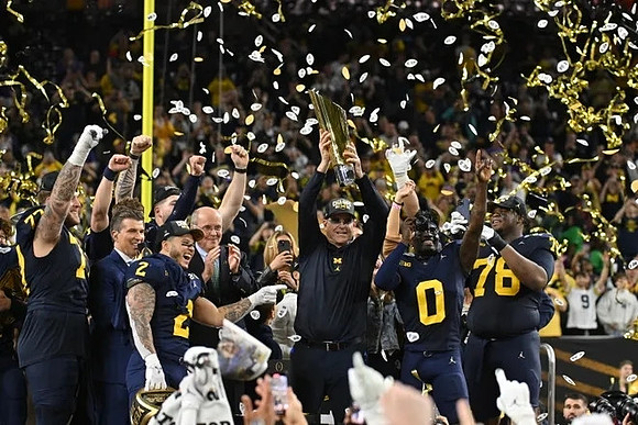 Trevor Keegan (77), Blake Corum (2), Jim Harbaugh, Mike Sainristil (0), Kenneth Grant (78), and National Championship Trophy