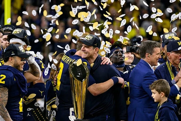 Blake Corum (2), J.J. McCarthy (9), Jim Harbaugh, Mike Sainristil (0), and National Championship Trophy