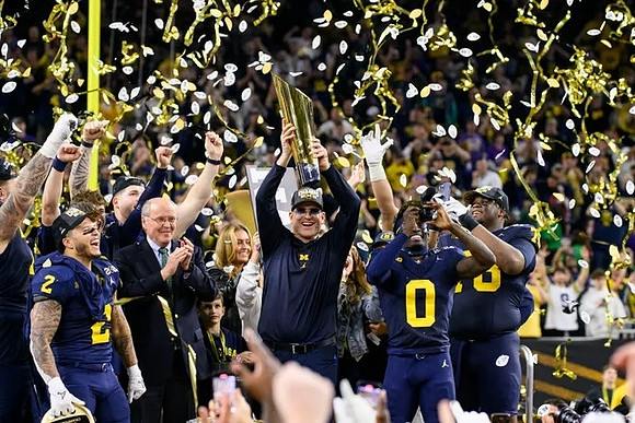 Blake Corum (2), Jim Harbaugh, Mike Sainristil (0), Kenneth Grant (78), and National Championship Trophy