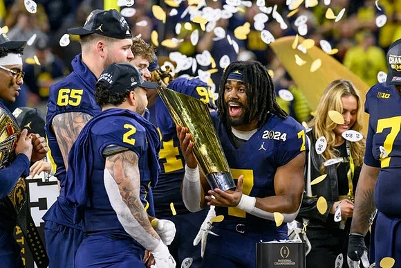Blake Corum (2), Zak Zinter (65), Donovan Edwards (7), and National Championship Trophy