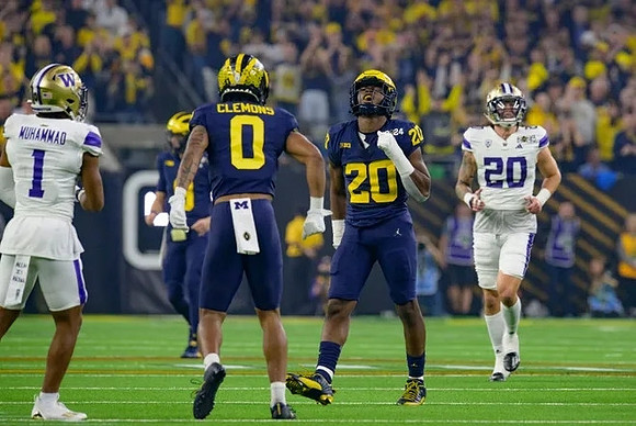 Mike Sainristil (0) and Jyaire Hill (20)