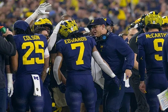 Junior Colson (25), Donovan Edwards (7), Jim Harbaugh, and J.J. McCarthy (9)