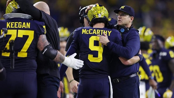 Trevor Keegan (77), J.J. McCarthy (9), and Jim Harbaugh