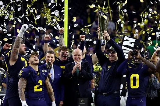 Trevor Keegan (77), Blake Corum (2), J.J. McCarthy (9), Jim Harbaugh, Mike Sainristil (0), and National Championship Trophy