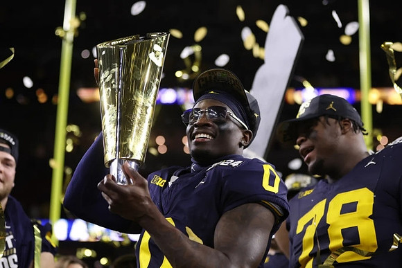 Mike Sainristil (0), Kenneth Grant (78), and National Championship Trophy