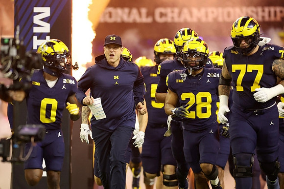 Mike Sainristil (0), Jim Harbaugh, Quinten Johnson (28), and Trevor Keegan (77)