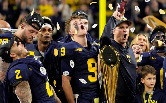 Blake Corum (2), Zak Zinter (65), Will Johnson (2), J.J. McCarthy (9), Jim Harbaugh, Mike Sainristil (0), and National Championship Trophy