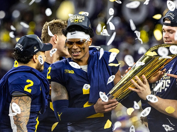 Blake Corum (2), J.J. McCarthy (9), Will Johnson (2), Zak Zinter (65), and National Championship Trophy