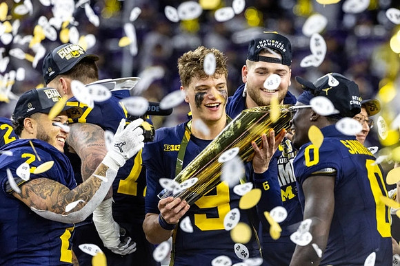 Blake Corum (2), Trevor Keegan (77), J.J. McCarthy (9), Zak Zinter (65), Mike Sainristil (0), and National Championship Trophy
