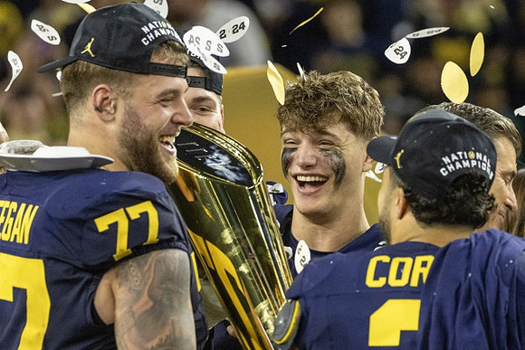 Trevor Keegan (77), Zak Zinter (65), J.J. McCarthy (9), Blake Corum (2), and National Championship Trophy