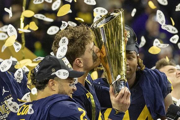 Blake Corum (2), J.J. McCarthy (9), Kris Jenkins (94), and National Championship Trophy