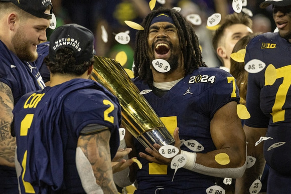 Zak Zinter (65), Blake Corum (2), Donovan Edwards (7), Myles Hinton (78), and National Championship Trophy