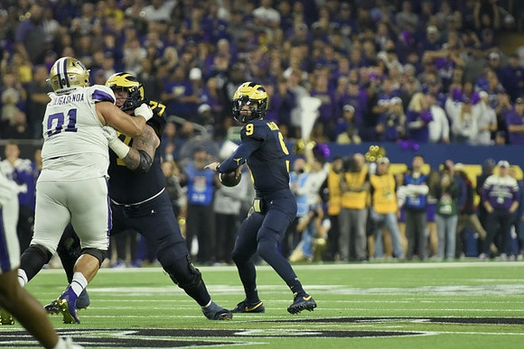 Trevor Keegan (77) and J.J. McCarthy (9)