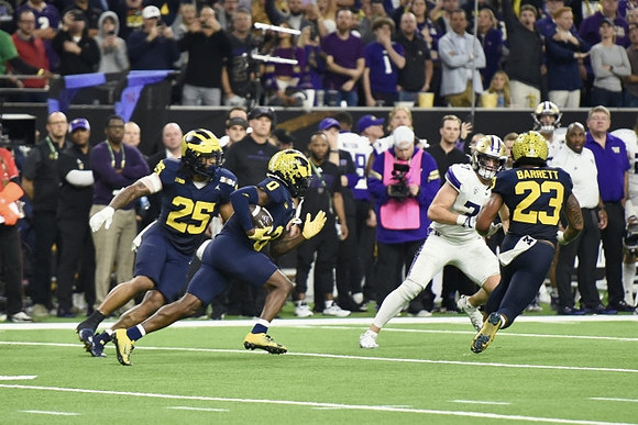 Junior Colson (25), Mike Sainristil (0), and Michael Barrett (23)