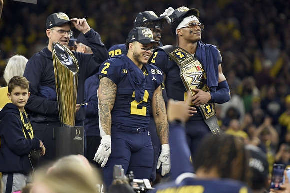 Jim Harbaugh, Blake Corum (2), Kenneth Grant (78), Will Johnson (2), and National Championship Trophy