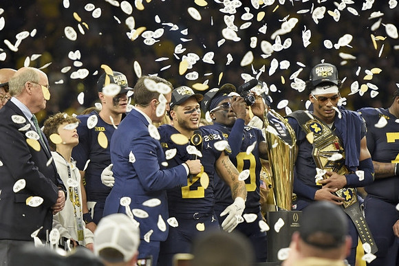 J.J. McCarthy (9), Blake Corum (2), Mike Sainristil (0), Will Johnson (2), and National Championship Trophy