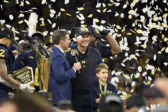 Blake Corum (2), Mike Sainristil (0), Jim Harbaugh, Kenneth Grant (78), and National Championship Trophy