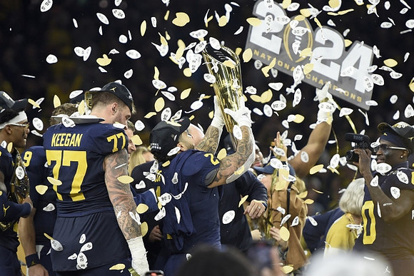 Will Johnson (2), Trevor Keegan (77), Blake Corum (2), Mike Sainristil (0), and National Championship Trophy