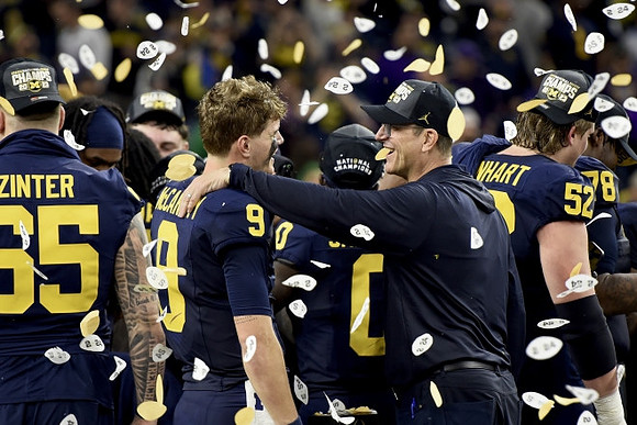 Zak Zinter (65), J.J. McCarthy (9), Jim Harbaugh, Karsen Barnhart (52), and Kenneth Grant (78)