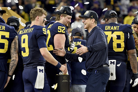 J.J. McCarthy (9), Karsen Barnhart (52), Jim Harbaugh, and Kenneth Grant (78)
