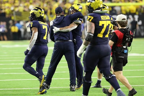Donovan Edwards (7), Jim Harbaugh, Blake Corum (2), and Trevor Keegan (77)