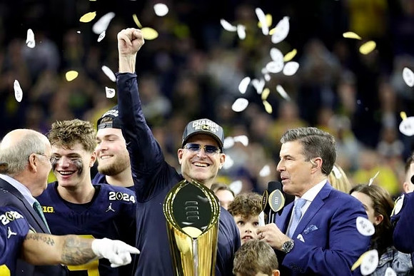 J.J. McCarthy (9), Zak Zinter (65), Jim Harbaugh, and National Championship Trophy