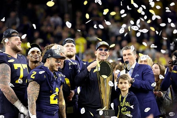 Trevor Keegan (77), Blake Corum (2), Will Johnson (2), Zak Zinter (65), Jim Harbaugh, and National Championship Trophy